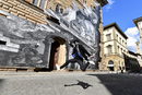 Артистът JR скача на фона на своя творба във Флоренция, Италия.