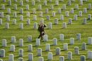 Военнослужещ поставя американски флагчета на гробище във Вирджиния, САЩ.