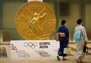 Жени минават покрай модел на медала за Олимпийските игри в Токио 2020 в кулата Nihonbashi Mitsui в Токио, Япония.