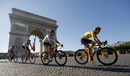 Колоездачите минават покрай Триумфалната арка в една от осемте обиколки в Париж.