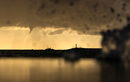 Лодки плават в Черно море в близост до торнадо на залез слънце край Сочи, Русия.