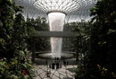Хора минават покрай изкуствен водопад на летището в Сингапур