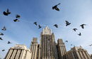 Гълъби летят пред сградата на руското външно министерство в Москва, Русия.