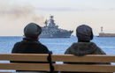 Жени наблюдават ракетния крайцер "Москва" на руските военноморски сили, който се връща в пристанището след проследяване на военни кораби на НАТО в Черно море, пристанището на Севастопол, Крим.