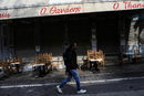 Мъж минава покрай затворен ресторант, докато собствениците му протестират срещу новите мерки, наложени за ограничаване на разпространението на коронавируса, които изискват клиентите да имат отрицателен тест за COVID-19, за да влязат в заведението, или да бъдат ваксинирани, Атина, Гърция.