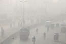 Автомобили се движат сред гъст смог в Лахор, Пакистан.
