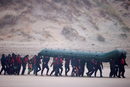 Група от над 40 мигранти се движи по плажа с надуваема лодка, за да опита да прекоси Ламанша, близо до Вимеро, Франция.