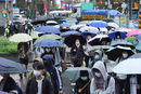 Хора вървят по улицата в дъждовен ден в Тайпе, Тайван