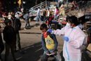 Дете реагира на тест за коронавирус на улица в Ню Делхи, Индия.