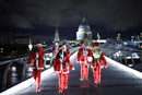 Хора, облечени като Дядо Коледа, минават по моста "Милениум", преди да участват в забавно бягане на Южния бряг в Лондон, Великобритания