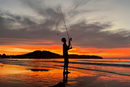Момче лови риба на плажа Банг Тао в Пукет, Тайланд.