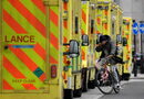 Мъж се движи с велосипед между линейки, паркирани пред Кралската лондонска болница в Лондон, Великобритания.