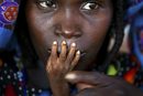 Нигерийска жена докосва с устни малката ръчичка на недохранения си едногодишен син в клиника за спешна помощ в град Тахоа (август, 2005 г.). Недохранването продължава да бъде един от най-сериозните проблеми на Африка.