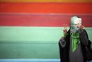 Привърженичка на прореформатора Мирхосеин Мусави крие лицето си зад негова снимка по време на предизборна демонстрация на стадион в иранската столица Техеран (9 юни 2009 г.)