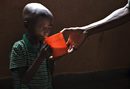 Страдащият от хронично недохранване Садики, на 9 години, получава чаша мляко в католическа кухня за бедни в град Ручуру в Източно Конго (13 ноември 2008 г.).  Районът е в постаоянна хуманитарна криза, която през миналата година бе допълнително усложнена от седмиците на сражения между правителствените сили и бунтовници от племето тутси, водени от ген. Лорен Нкунда.