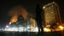 Репортер говори по телефона си на фона на горящия хотел "Тадж" в Мумбай (27 ноември 2008 г.). Популярната сред гостите на града сграда бе един от обектите на терористична атака, отнела живота на 166 души.