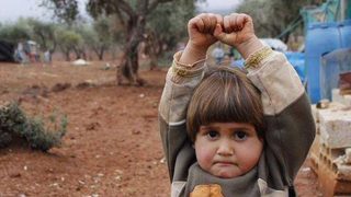 Снимка на сирийче, което се "предава" на фотограф, стана интернет хит