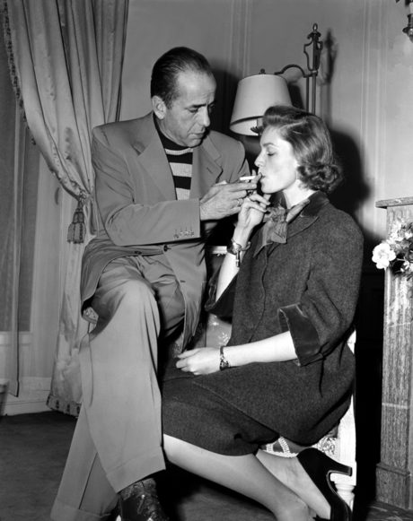 Хъмфри Богарт пали цигара на съпругата си Лорън Бaкoл.