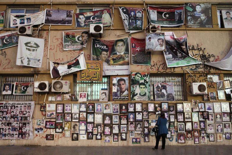 Жена разглежда снимки на бунтовници, загинали в гражданската война, закачени на стената на съда в Бенгази на 10 септември 2011 г.