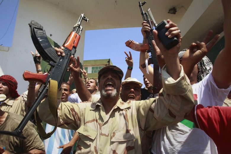 Либийски бунтовници празнуват превземането на тренировъчен център за жени офицери в Триполи на 22 август 2011 г.