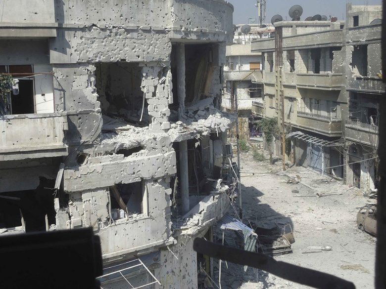Силно повредени от улични сражения сгради в сирийска град Хомс, заснети на 20 юни.