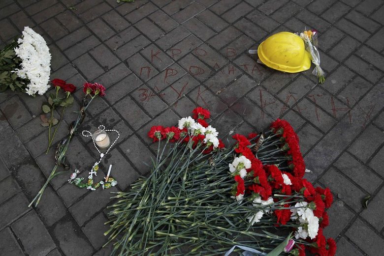 Цветя, цигара, бонбони, кръст и надпис "Кръв, проляна за Украйна" бележат мястото, където е загинал участник в протеста. В петък вечер бяха погребан ипървите загинали от сблъсъците.