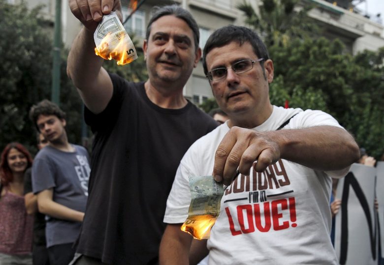Привърженици на твърдата линия на правителството гориха банкноти евро пред парламента в знак на подкрепа.