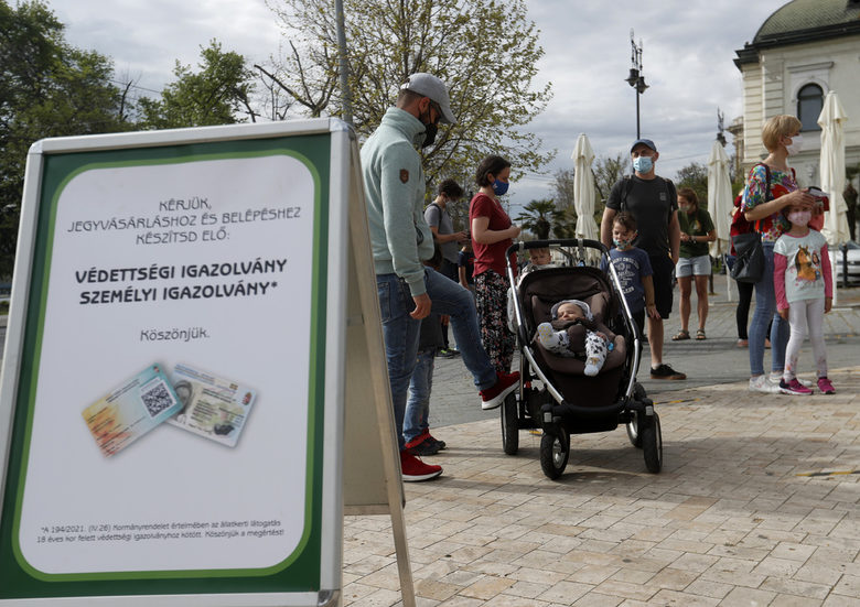 Унгарци чакат за влизане в зоологическата градина в Будапеща на фона на плакат, че това става срещу зелен пропуск, който беше въведен в страната през май