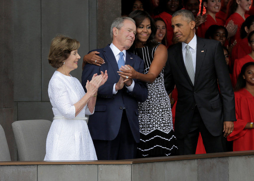 Първата дама на САЩ Мишел Обама прегръща президента Джордж Буш (2001-2009 г.), след като пристигат за откриването на Музея на афроамериканската история и култура във Вашингтон. Барак и Мишел Обама и предшествениците им в Белия дом Джордж и Лаура буш участваха в церемонията по откриването.<br /><br />Държавният глава изрази надежда, че новият музей, който показва и възходите, и трагедиите на чернокожите в САЩ ще помогне за обединяването на нацията. "Надявам се, че този музей ще ни помогне да говорим един с друг, по-важно – да се вслушаме един в друг. И най-вече – да се видим. Черни, бели, латино, коренни американци и азиатски американци – да видим как нашите истории ни обединяват", заяви Барак Обама.<br /><br />Музеят официално отвори врати в събота. Той съхранява 36 хил. експоната, които проследяват пътя на афроамериканците от годините на робство в началото на 19 в. до борбите за граждански права през 20 в.