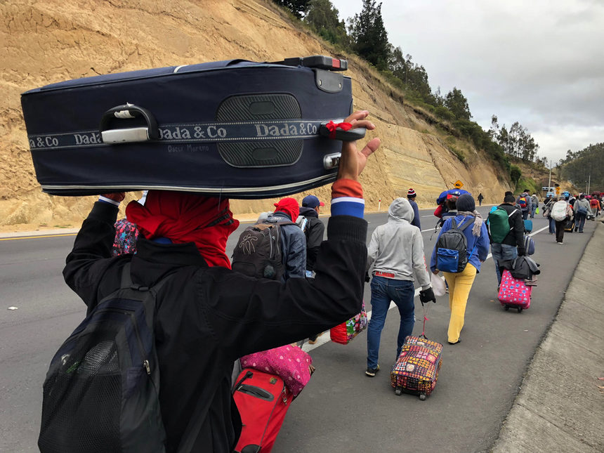 Мигранти от Венецуела вървят по магистрала в Еквадор към Перу.