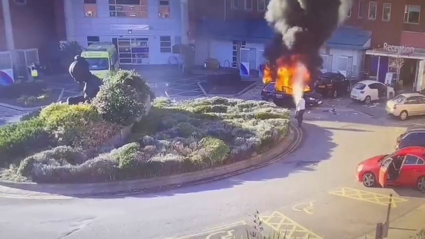 На кадри от камера за наблюдение се вижда как мъж гаси горящо такси след експлозия пред болница в Ливърпул, Великобритания.
