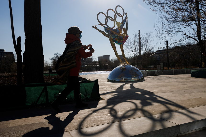 Жена минава пред централата на олимпийския комитет в Пекин, където се очаква да се проведат Зимните олимпийски и параолимпийски игри през 2022 г.