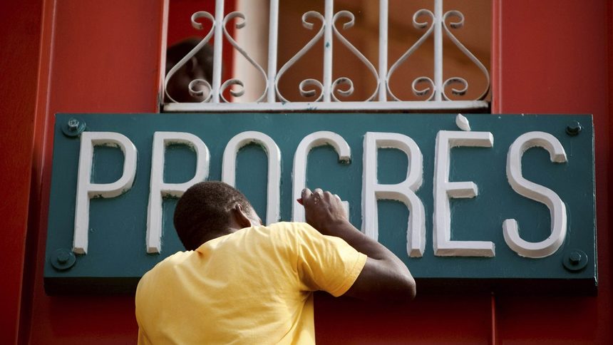 Мъж боядисва знак "Напредък" върху възстановения неотдавна Железен пазар в центъра на Порт-о-Пренс, построен през 1890 г. Въпреки това напредъкът във възстановяването на Хаити е бавен