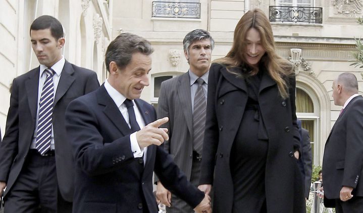 Никола Саркози подава ръка на съпругата си пред Елисейския дворец на 17 септември