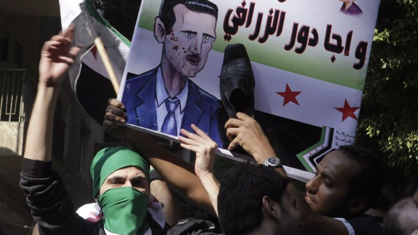 Сирийци, живеещи в Египет, удрят с обувка карикатура на президента Башар ал Асад