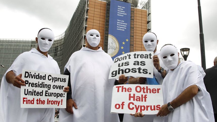 Протестиращи с плакати: "Разделен Кипър председателства ЕС: Открийте иронията!", "Не се отнасяйте с нас като с призраци" и "Другата половина на Кипър".