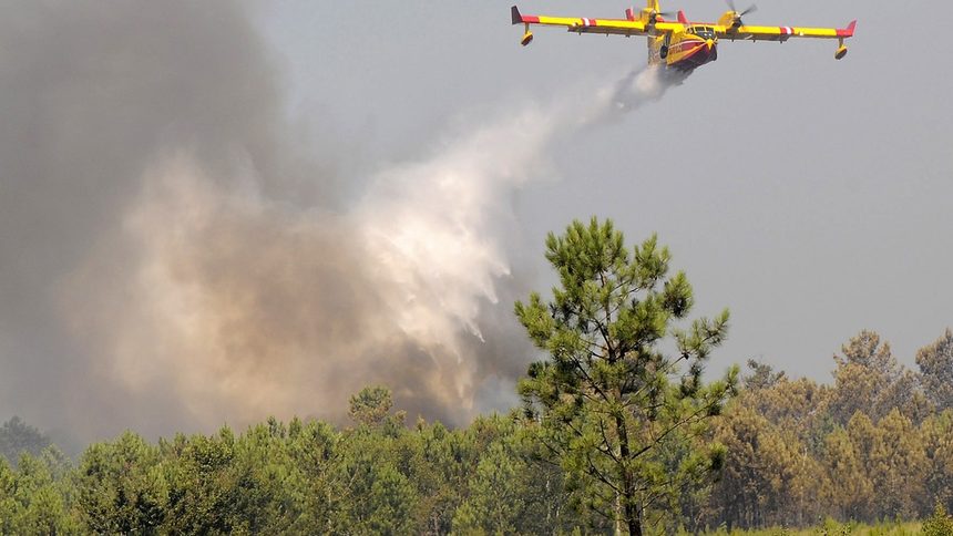 Специализиран самолет за борба с огъня облива с вода пламналата гора близо до Лакано