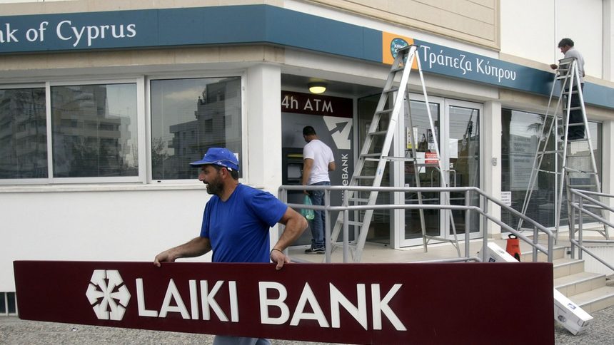 Работници премахват надписите на закритата Popular Bank of Cyprus (Laiki)