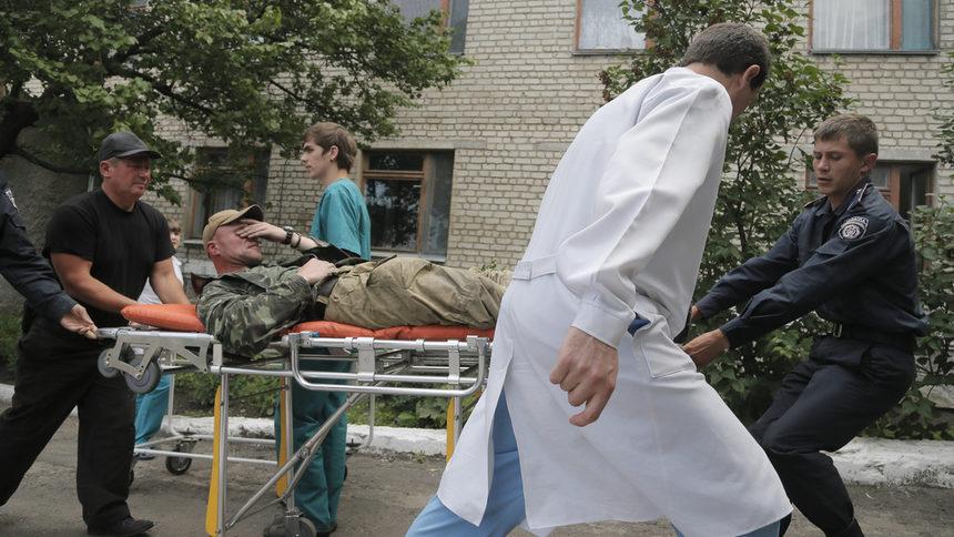 Украински войници носят ранен към болницата в Славянск