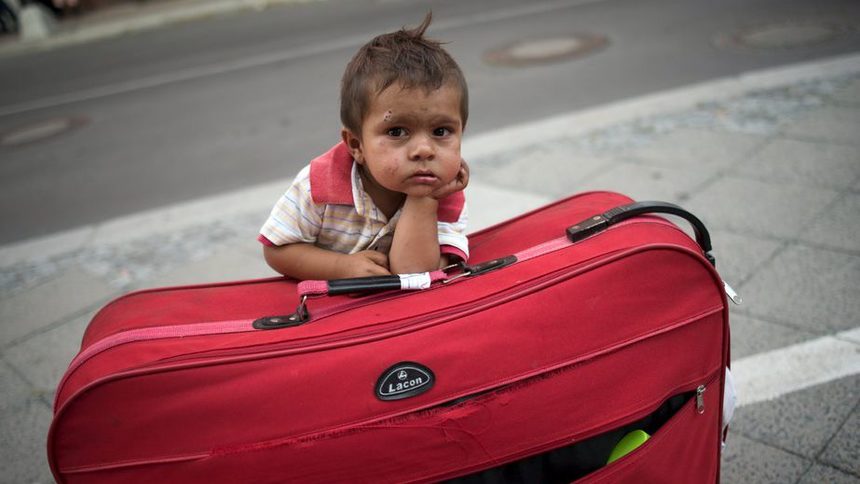 Дете чака родителите си, докато семейството се готви да напусне берлинскаа Агенция за здравеопазване и социално убежище - органът, където се подават молбите за получаване на бежански статут.