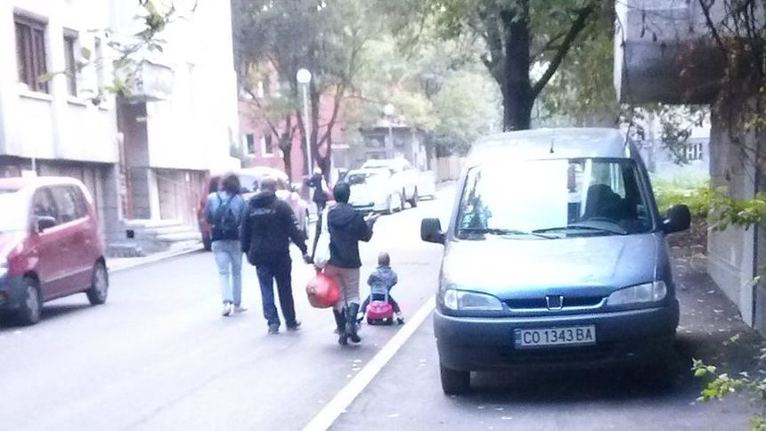 Детето показва на батковците къде е мястото на автомобилите в профила на улицата