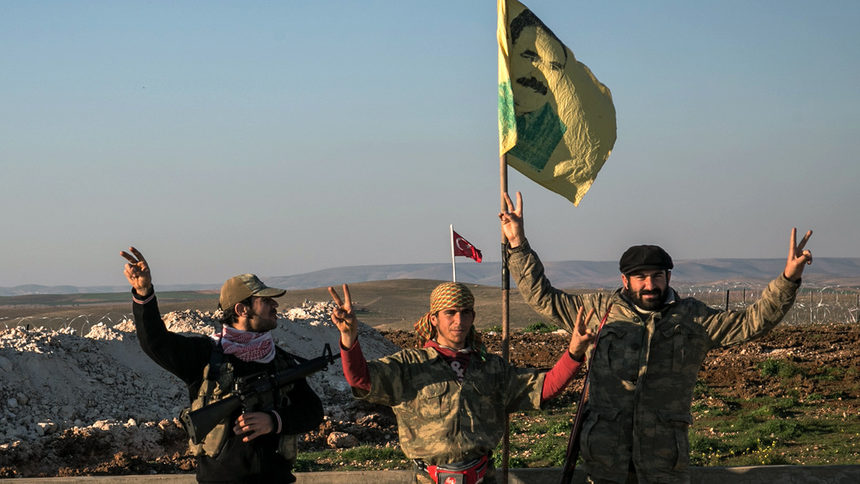Бойци на кюрдските Народни милиции за самоотбрана Y.P.G. размахват знаме с лика на намиращия се в затвора лидер на ПКК Абдула Йоджалан.