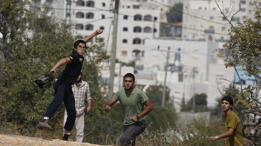 Израелски момчета хвърлят камъни по време на сблъсъци с палестинци в покрайнините на еврейското селище Кирият Арба в ивицата Газа.