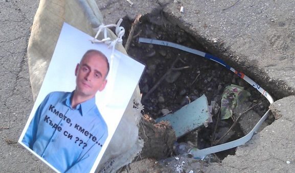 На ул. "Иван Сусанин" 21 в "Павлово" има дълбока дупка, и докато я заобикалят шофьорите се любуват на лика на кмета на район "Витоша" Теодор Петков