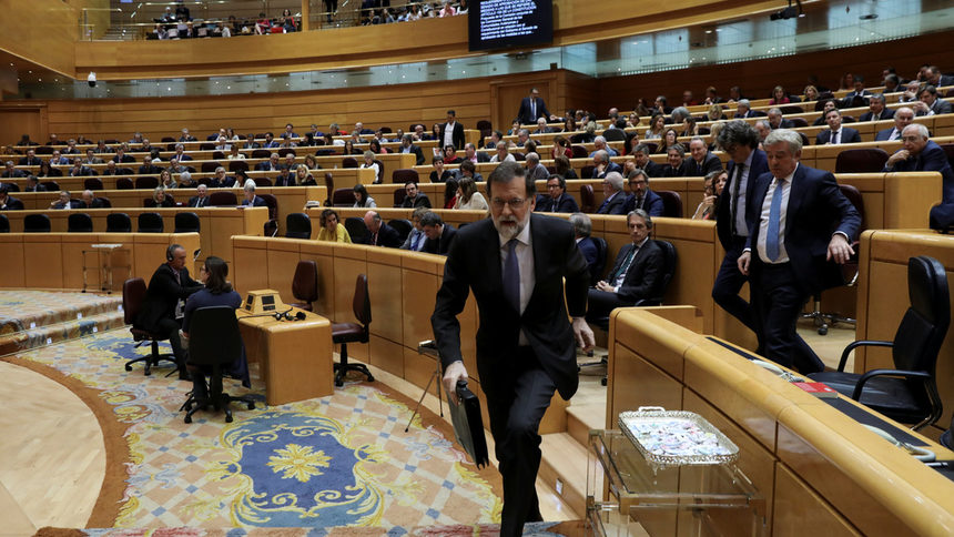 Испанският премиер Мариано Рахой напуска пленарната зала на Сената.