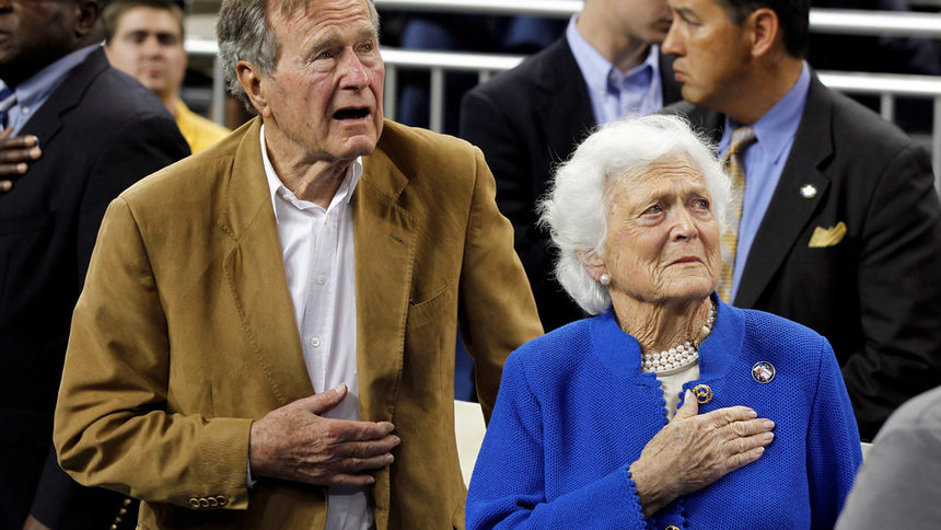 Кадърът е от април 2011 г., когато заедно със съпругата си Барбара слуша изпълнението на националния химн преди финала на баскетболна среща в университет в Хюстън. Барбара Буш почина през април тази година.