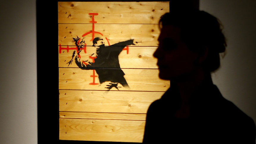 Жена разглежда произведение на Банкси по време на негова изложба в Берлин