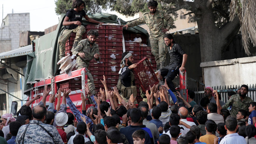Подкрепяни от Турция бойци раздават хляб в Тел Абяд.