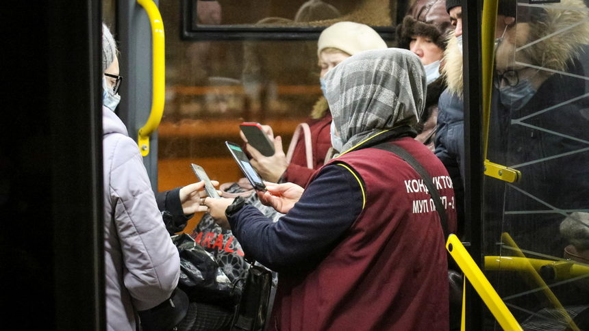 Кондуктор проверява QR кодовете за COVID сертификат на пътници в обществения транспорт в Казан.